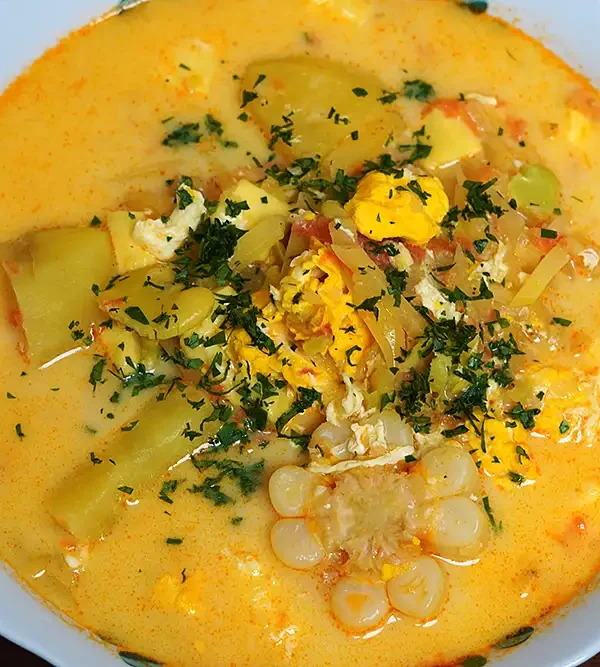 Chupe de Ollucos peruano en tazón de barro, con ollucos, papas, choclo y huevo. Sopa andina tradicional.
