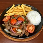 Lomo Saltado peruano con papas fritas y arroz blanco.