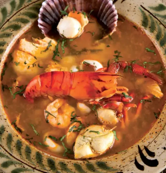 Parihuela peruana con mariscos frescos en tazón rústico. Sopa tradicional de la costa del Perú.
