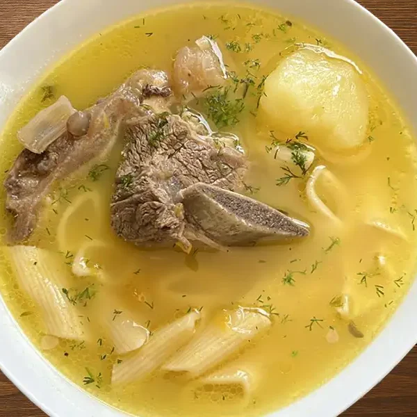 Caldo de carne de res peruano con papas, fideos cabellos canuto y cilantro fresco