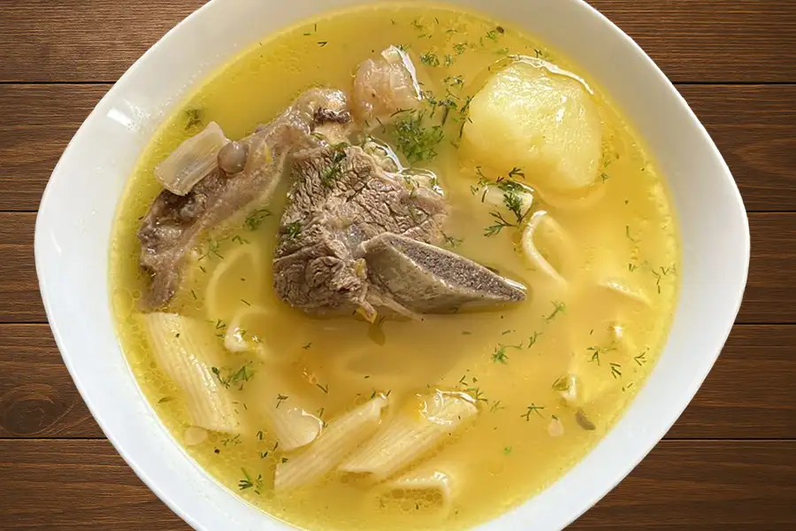 Caldo de carne de res peruano con papas, fideos cabellos canuto y cilantro fresco